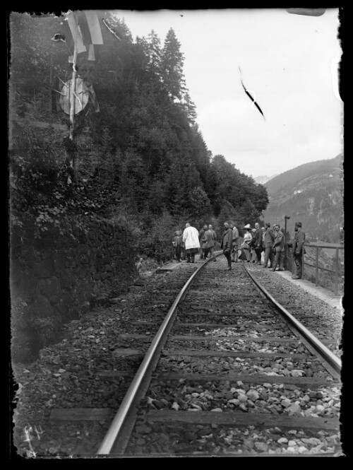 [Streckenaufnahme mit Gruppe von Personen auf der Brücke im km 112,4 zwischen Langen am Arlberg und Klösterle]