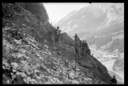 [Mitarbeiter der Lehnenpartie bei der Loslösung lockeren Gesteins oberhalb der Bahnstrecke zwischen Flirsch und Schnann Hst neu im km 88,5]