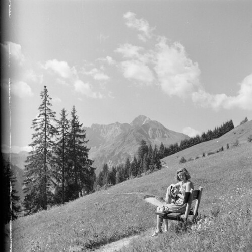 Frau auf einer Bank im Gebirge