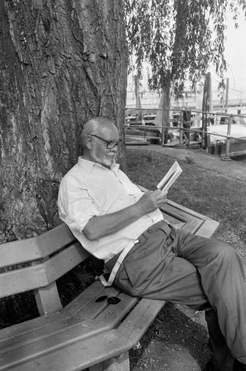 Fred Liewehr liest ein Buch auf einer Bank der Seeanlagen